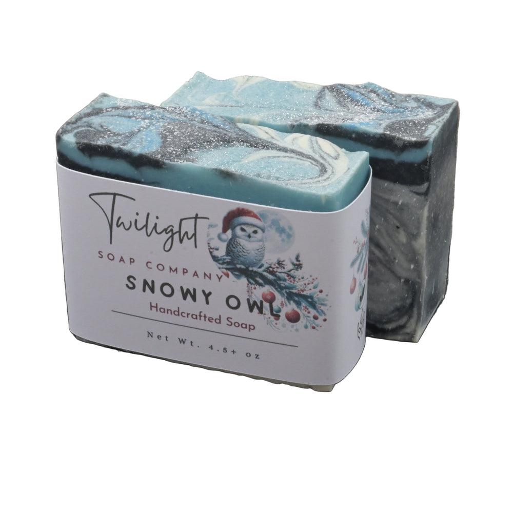 Bar of soap with packaging labeled 'Snowy Owl' from Twilight Soap Company on a dark surface.