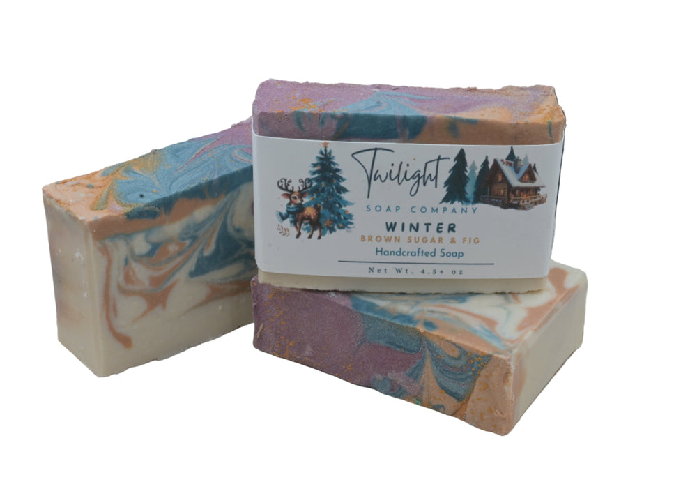 Three bars of soap with a Twilight Soap Company label on a wooden surface.