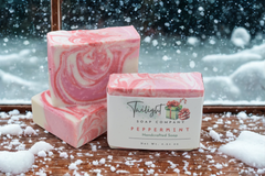 Pink and white swirled soap bars with a Twilight Soap Company label on a wooden surface.