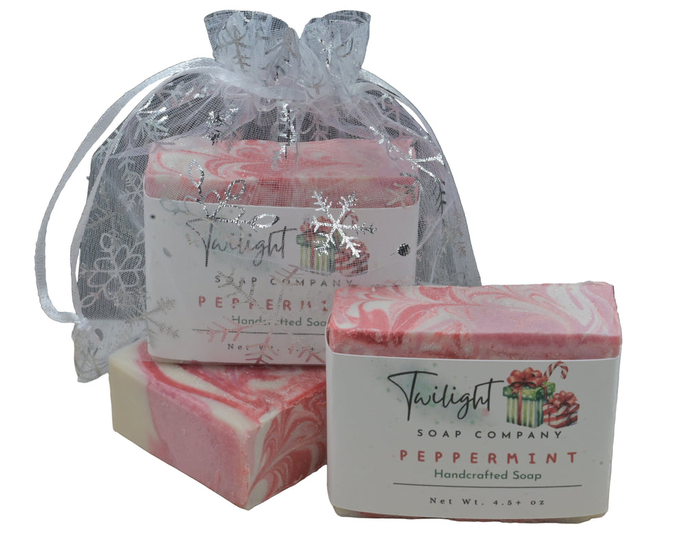 Two bars of Twilight Soap Company peppermint soap on a wooden surface with a black background.
