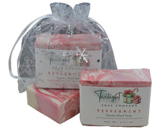 Two bars of Twilight Soap Company peppermint soap on a wooden surface with a black background.