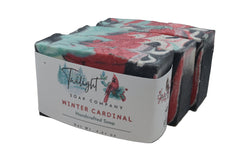 Handcrafted soap bar with a label from Twilight Soap Company on a wooden surface.