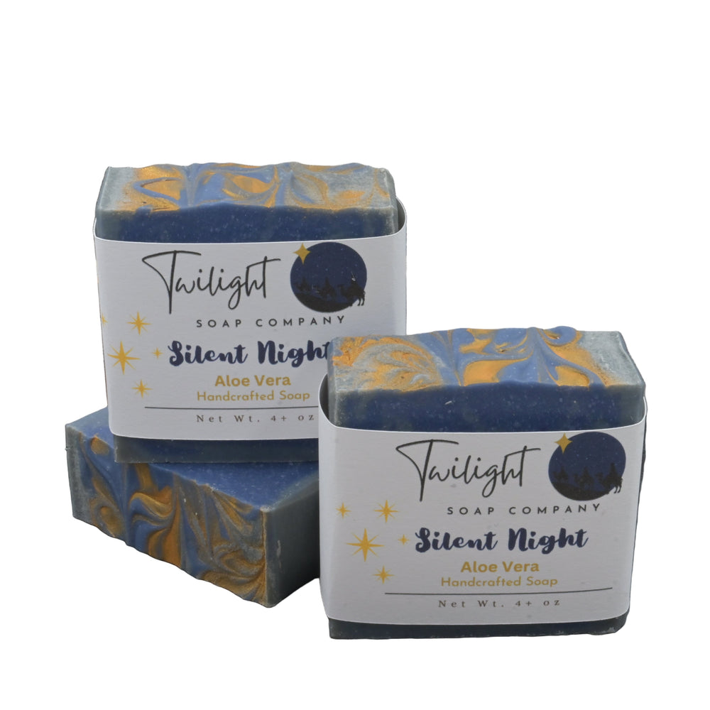 Two boxes of Twilight Soap Company's 'Silent Night' soap on a textured surface with a stone wall background.