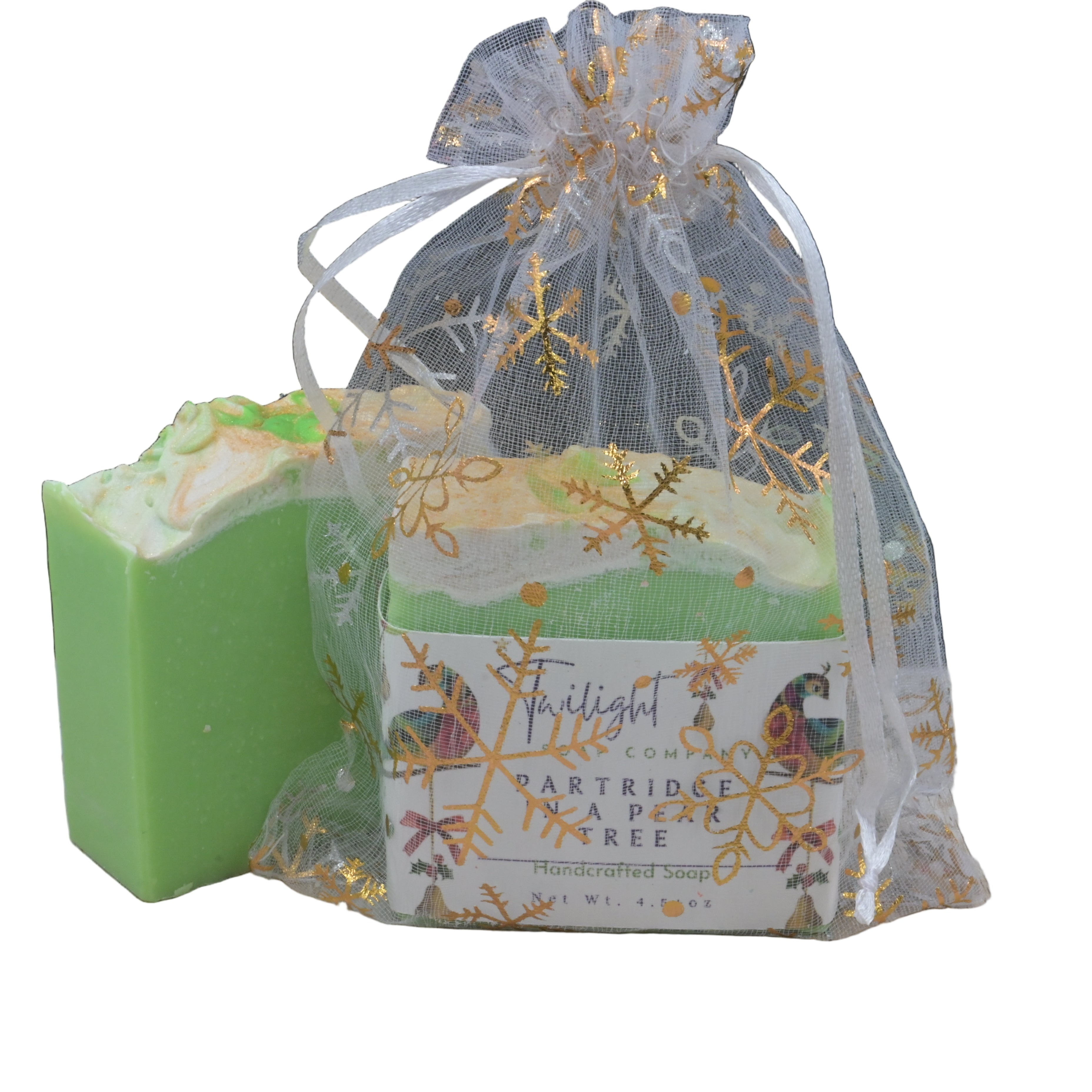 Green soap bar next to a decorative gift bag on a wooden surface with a dark background