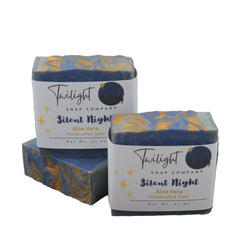 Two boxes of Twilight Soap Company's 'Silent Night' soap on a textured surface with a stone wall background.